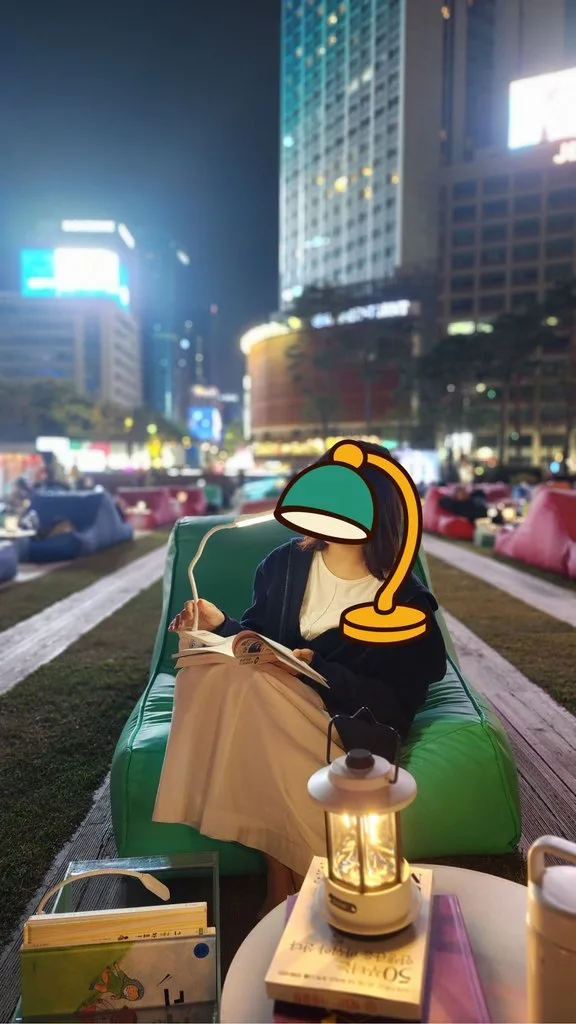 서울 야외 도서관의 초록색 빈백에 앉아 책을 읽는 아내